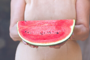 Woman holding slice of watermelon