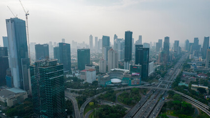Aerial view of the city traffics at semanggi Roundabout, Jakarta, Indonesia. Aerial view on highways and skyscrapers with noise cloud. Jakarta, Indonesia