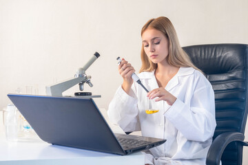 Woman scientist. Young girl is engaged in research. Laboratory assistant with laptop. Portrait of...