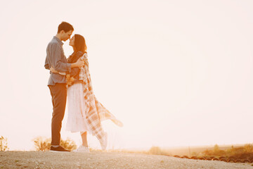 Happy couple in love standing on the street at sunset