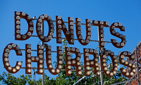 the text donuts and churros on circus style sign