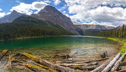 Fototapeta na wymiar Emerald Green Luellen Lake Scenic Landscape Panorama with Castle Mountain Peak Rising High in the Background. Summertime Hiking in Banff National Park, Canadian Rockies