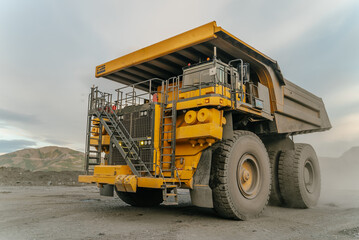 A close-up of a dump truck. The action takes place in an open pit.