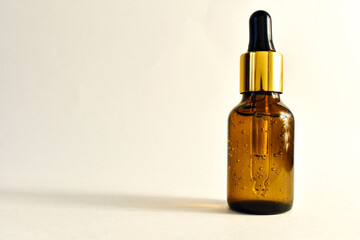 Cosmetic. Yellow liquid in brown bottle with pipette. Brown bottle with bubbles. High quality photo. space for text