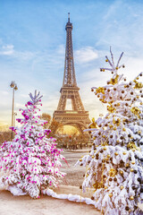 Eiffel Tower is the main attraction of Paris on the background of  frosty Christmas trees covered by snow in winter. Travel Greeting Card from Paris with love, France