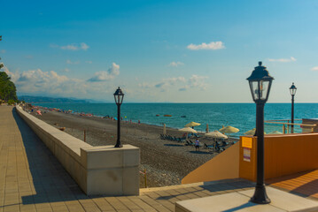 Obraz premium KOBULETI, GEORGIA: Landscape with a view of the promenade by the beach on the Black Sea on a sunny summer day.