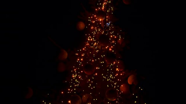 Night Christmas decoration of the city. Christmas tree with red balls and lights at night on the clit.