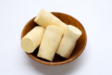 Cassava in wooden bowl on white background.