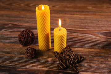 Yellow wax candle from foundation on a wooden background. Ecological product made from honeycombs....