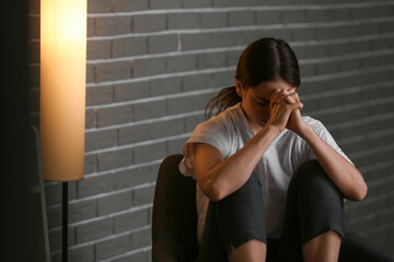 Young depressed businesswoman in dark office