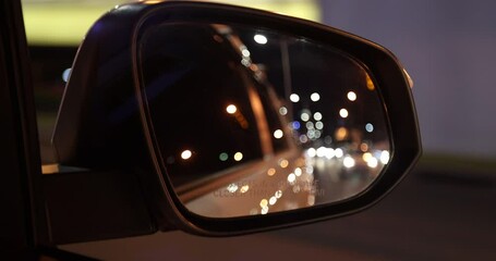 Driving car on night city road, Rear view mirror view