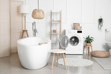 Interior of bathroom with modern washing machine