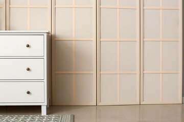 Modern chest of drawers near folding screen
