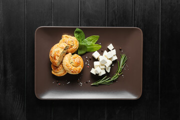 Puff pastry stuffed with spinach and feta cheese on dark wooden background