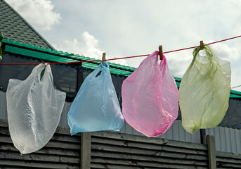 disposable colored bags are dried on a rope for reuse against a backdrop of clouds, Plastic bags are hard to degrade. horizontal