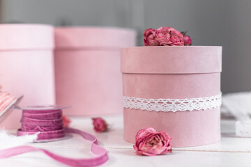 Beautiful pink round gift wrapping is decorated with narrowed roses. 