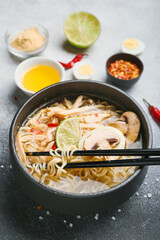 Bowl of tasty Thai chicken soup on black and white background