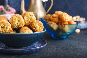 Bowl with delicious baklava on dark background, closeup