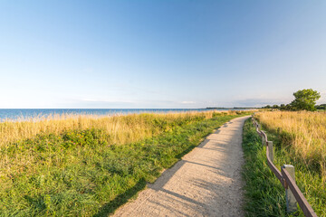 Footpath at the shoreline of the Baltic Sea during scenic evening light in Pottloch in Northern Germany