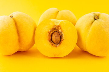 Fresh yellow peaches on yellow background