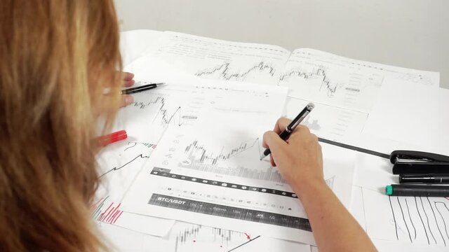 Woman investor at work analyzes the stock market.