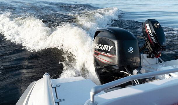 Sankt-Petersburg, Russia, August 27, 2021: Modern new fishing sport boat with a brand new Mercury FourStroke outboard engine speeding on the lake.