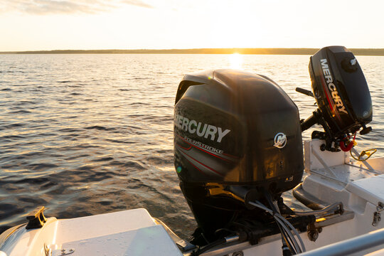 Sankt-Petersburg, Russia, August 27, 2021: Modern new fishing sport boat with a brand new Mercury FourStroke outboard engine speeding on the lake at the sunset