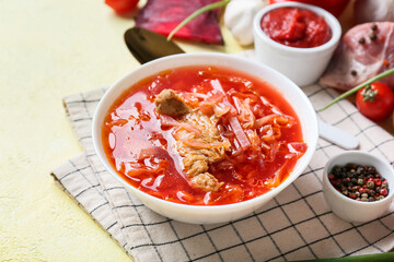 Bowl of tasty borscht on color background