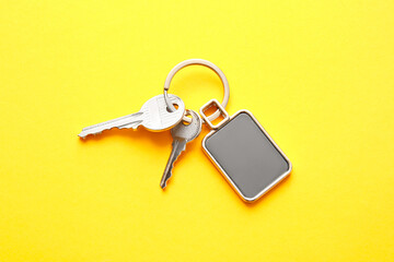 Keys with stylish keychain on color background