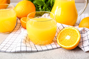 Glasses of tasty orange juice on light background, closeup