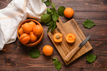 Bowl with tasty ripe apricots on wooden background
