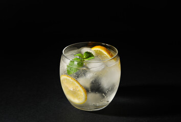 Glass of cold gin and tonic on dark background