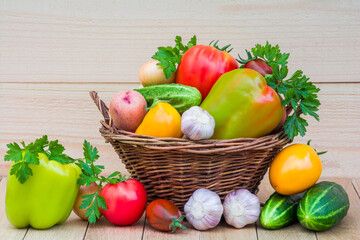 Fresh ripe vegetables in a wicker basket on a wooden table