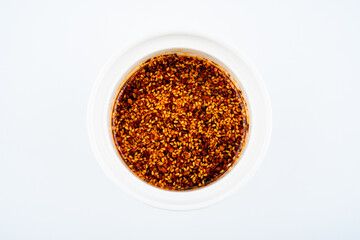 A cup of sesame oil chili on white background
