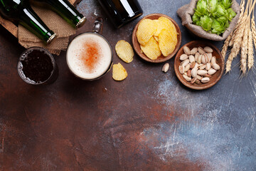Lager beer mug, bottles, hops and wheat on old stone table