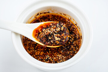 A cup of sesame oil chili on white background