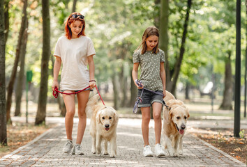 Girls with golden retriever dog