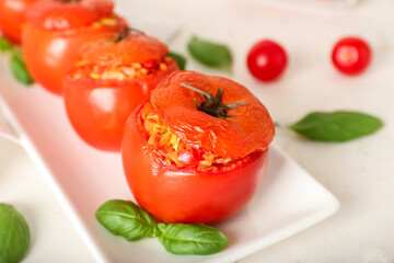 Plate with tasty stuffed tomatoes on light background, closeup