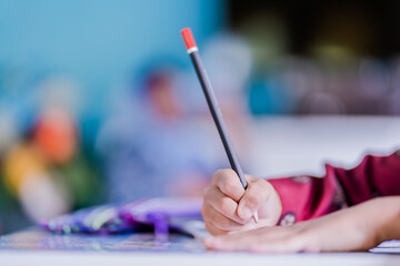 children use pencils to write items
