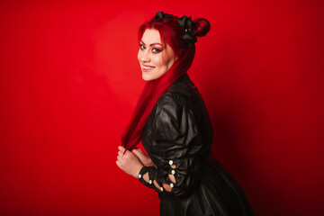 Informal girl with red hair and bright makeup. Rocker in a black leather suit