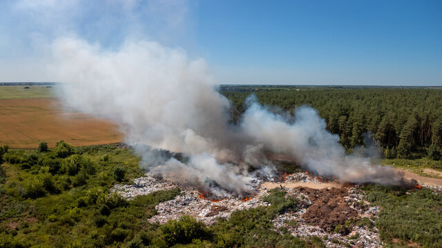 Drone photo of different rubbish including toxic plastic burning at waste disposal site. Environmental pollution