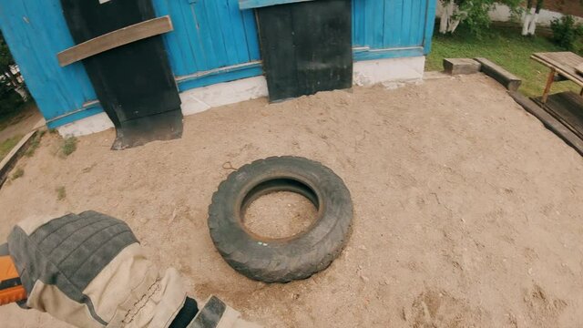 Serious physical training of firefighters and rescuers. A firefighter strikes a car tire with a sledgehammer. A difficult cardio exercise for developing endurance. 
