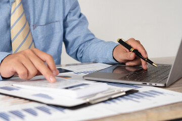 Fototapeta premium Businessman is deeply reviewing a financial report for a return on investment or investment risk analysis.