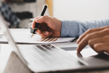Businessman is deeply reviewing a financial report for a return on investment or investment risk analysis.