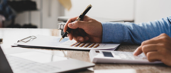 Businessman is deeply reviewing a financial report for a return on investment or investment risk...