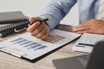 Businessman is deeply reviewing a financial report for a return on investment or investment risk...