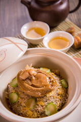 chinese wok egg fried rice with whole abalone in hot clay pot on wood background asian halal banquet menu