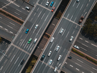 Top up aerial drone view of elevated road and traffic junctions in Chinese metropolis city during sunny day golden hour. Modern construction design of traffic ways to avoid traffic jams. Few vehicles.