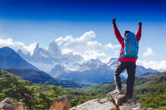 hiker celebrating success on top of a mountain in a majestic Patagonia mountain landscape. Fitz Roy, Argentina. Mountaineering sport lifestyle concept