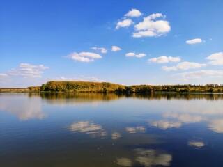 Photo of a lake against a blue sky with a reflection
